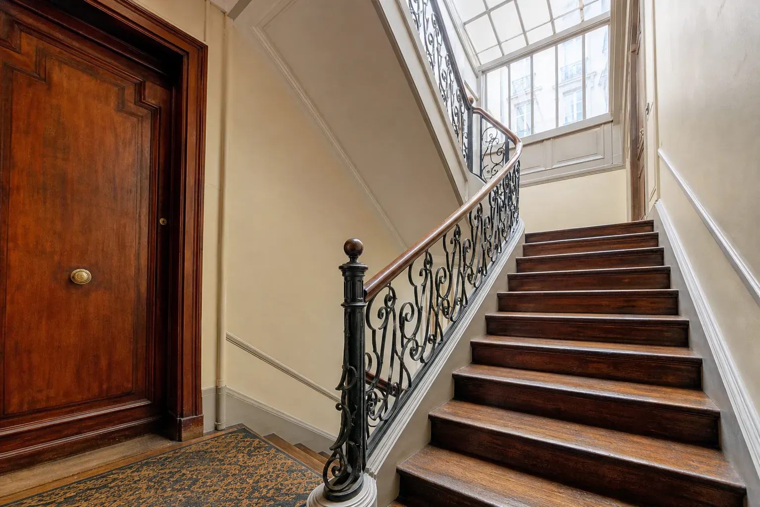 Escalier en bois ancien d’un immeuble parisien vu depuis le premier palier