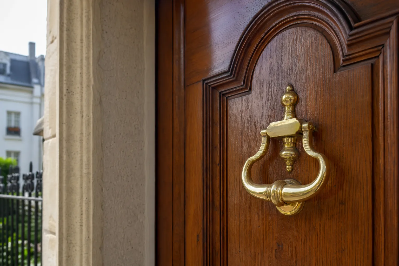 Porte d’entrée en bois verni avec heurtoir en laiton d’un immeuble résidentiel